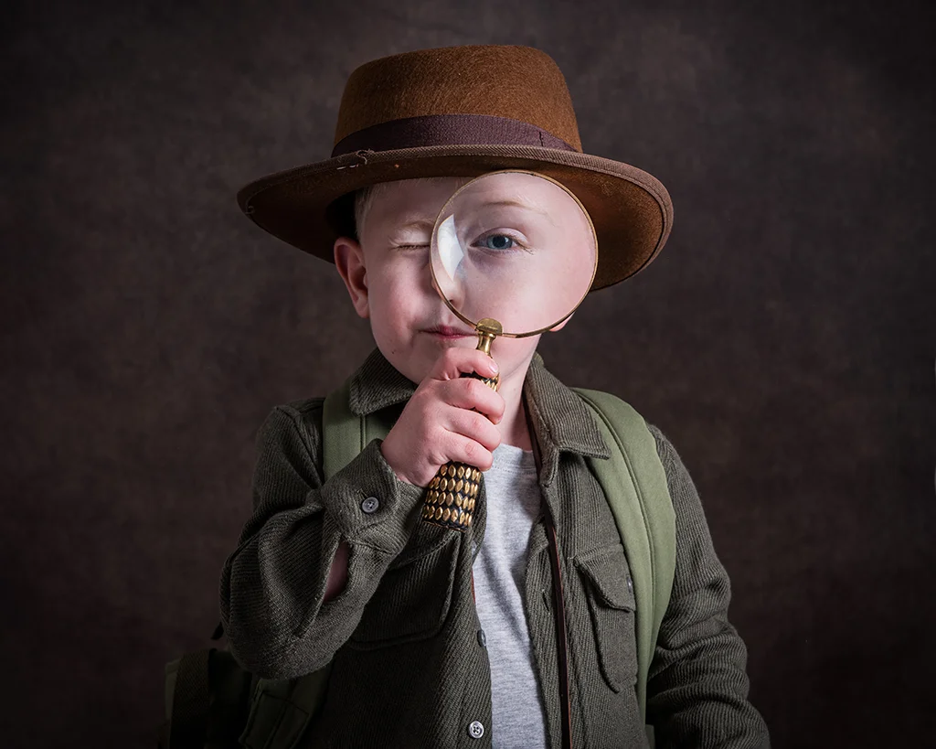 Boy dressed as an Explorer looking through a Magnifying Glass