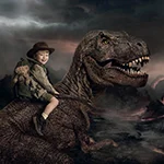 A Young boy with his teddy in a backpack riding a T-Rex.